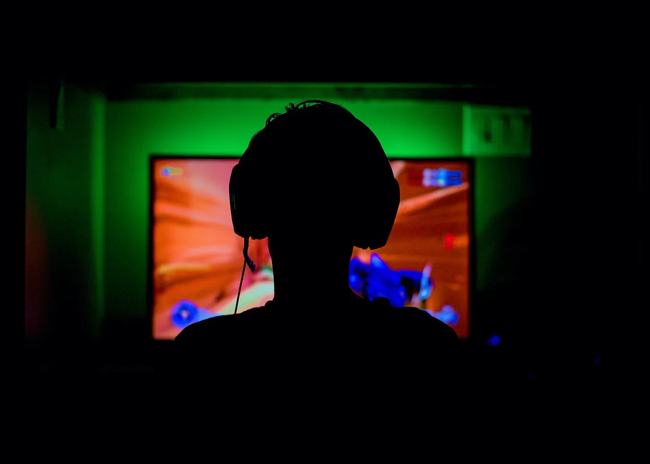 gaming addiction - silhouette of a young teenager playing a video game