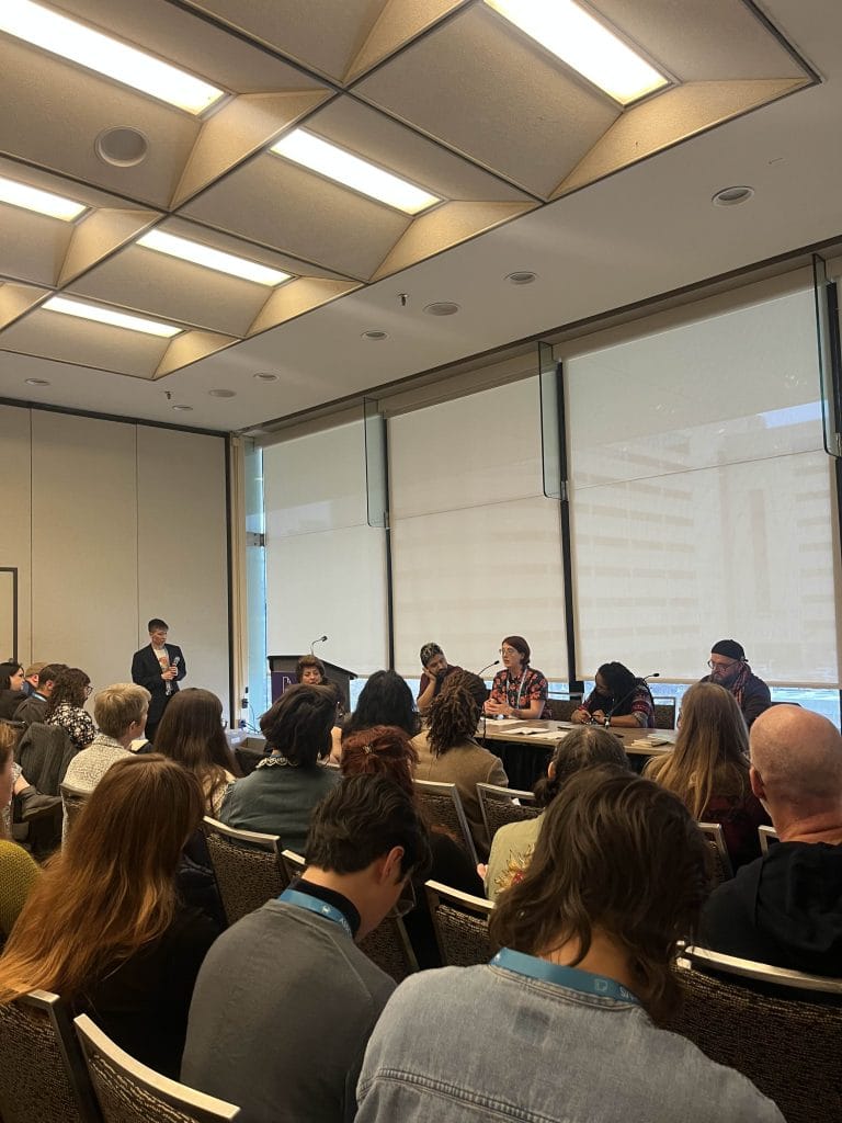 Five people speaking at a convention hall about board game design at AWP 2026 in Baltimore