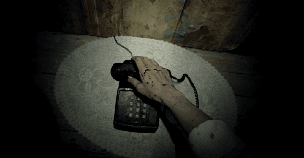 Resident Evil 7 Review - screenshot of the gaunt, bloodied hand of a woman picking up an old landline telephone receiver
