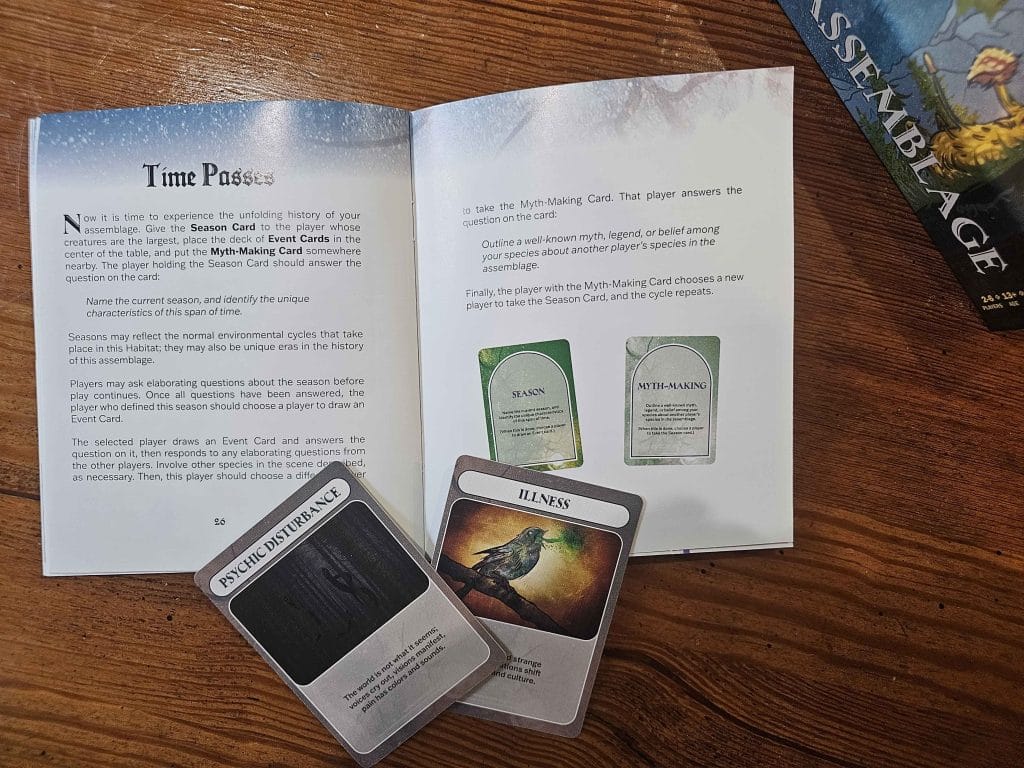 A photo of the Assemblage TTRPG guidebook and the pages "Time Passes" with two cards in close-up, featured in an Assemblage TTRPG review
