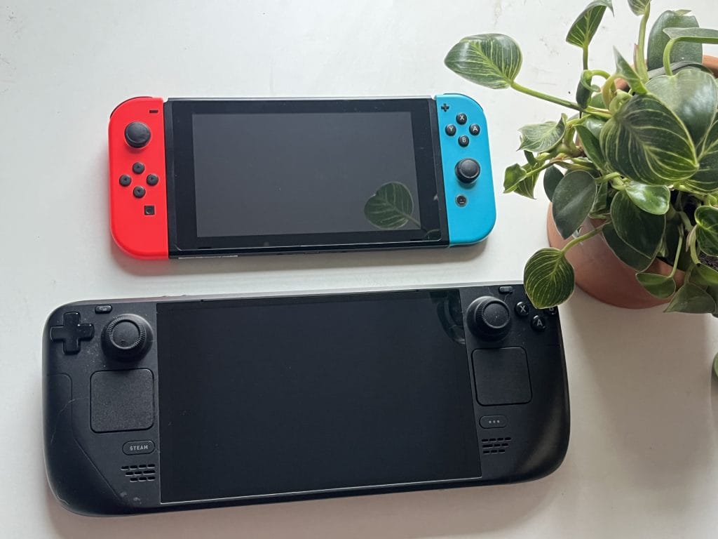 In a piece about the Steam Deck Mechanism Gaming Pillow, this photo compares a Nintendo Switch and a Steam Deck. A plant is in the corner. 
