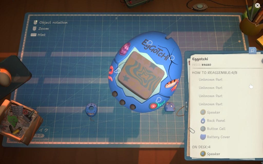 A screenshot of ReStory: Chill Electronics Repair showing a close-up of an EGoTcHi which is a reference to the famous Tamagotchi toys). This is in a game diary about if ReStory is a good cozy game.
