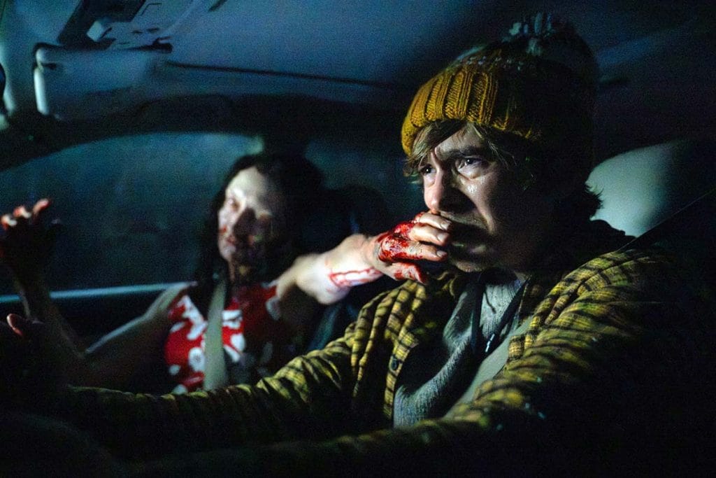 Resident Evil (2026 film) - Bryan in the driver's seat of a car while a zombie with a bloody hand reaches for his face
