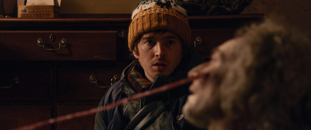 Resident Evil (2026 film) - Bryan looking at a dead body with what appears to be an arrow or stick lodged in its face