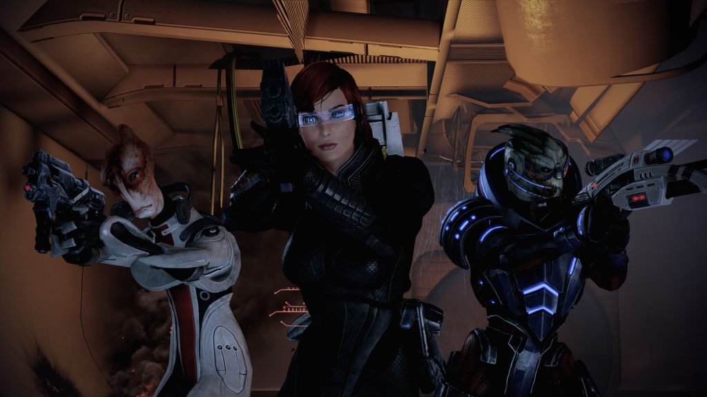 A screenshot of Mass Effect 2 showing FemShep with Mordin and Garrus walking with guns. This screenshot is featured in an op-ed about why the shut-down of BioWare is so sad and bad for the games industry.