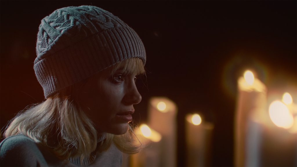 Tenebris Somnia Review: A screenshot of Julia in FMV lit by candles. 